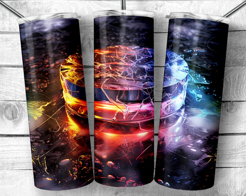 May include: A set of three stainless steel tumblers with a colorful abstract design. The design features a circular shape with a cracked, shattered effect in shades of red, orange, yellow, blue, and green. The background is a dark, textured surface.