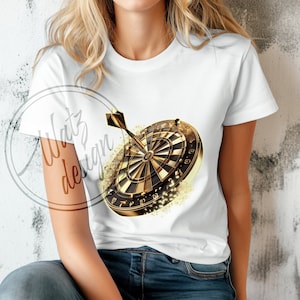 以下が含まれることがあります： 中央に金のダーツボードとダーツが描かれた白いTシャツ。ダーツボードは金色のキラキラで囲まれています。