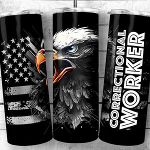 Könnte beinhalten: Ein schwarzer und weißer Becher mit einem Weißkopfseeadler-Design und dem Text "Correctional Worker" in Weiß. Der Adler hat ein blaues Auge und einen orangefarbenen Schnabel. Der Becher hat ein schwarz-weißes amerikanisches Flaggen-Design an der Seite.