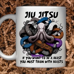 May include: White ceramic mug with a graphic of a purple, blue, brown, and gray octopus with the text "Jiu Jitsu" and "If you want to be a beast you must train with beasts".