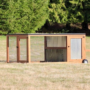 May include: A wooden and metal chicken coop with a wire mesh enclosure. The coop has a door on the right side and a smaller door on the left side. The coop is on wheels and has a metal roof.