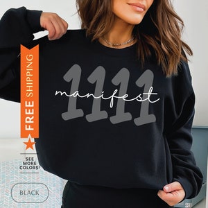 May include: Black sweatshirt with the text "1111 manifest" in white and gray lettering.