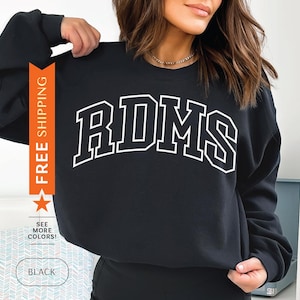 Könnte beinhalten: Schwarzer Pullover mit weißem Text, der "RDMS" lautet.