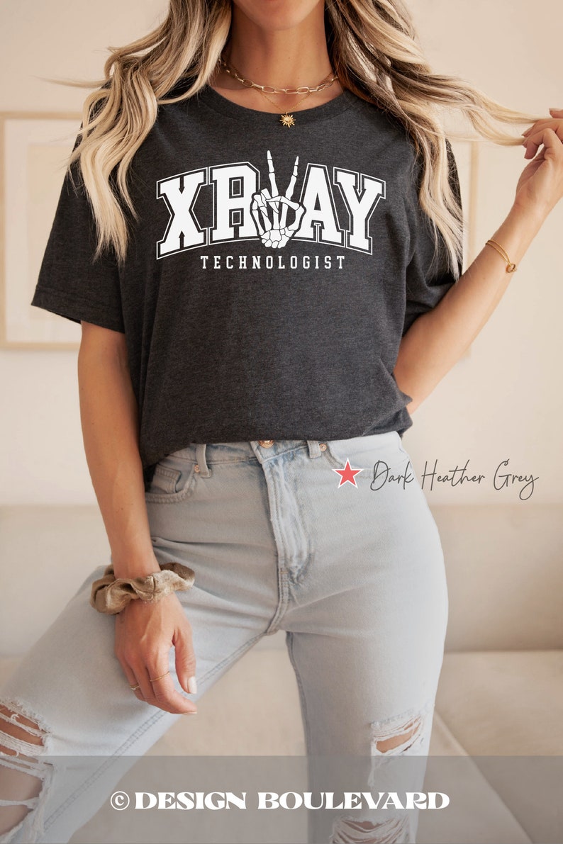May include: Dark heather grey t-shirt with a white graphic of a skeleton hand making a peace sign and the text "XRAY TECHNOLOGIST".