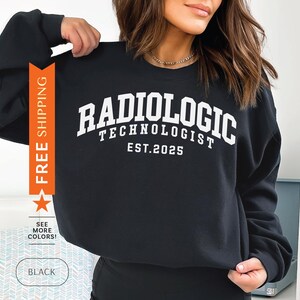 Könnte beinhalten: Schwarzer Pullover mit weißem Text, der "Radiologic Technologist Est. 2025" lautet.