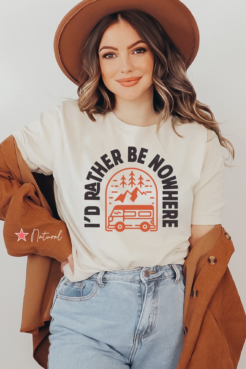 May include: A white t-shirt with a black graphic that says "I'd rather be nowhere" with a mountain and a van design in orange.
