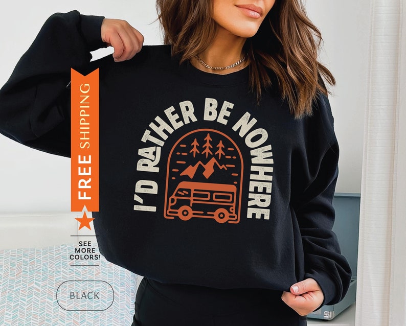Pode incluir: Camisola de moletom preta com uma estampa gr&aacute;fica de uma van dirigindo por uma paisagem montanhosa. O texto "I'd rather be nowhere" &eacute; impresso em um arco branco acima da van.