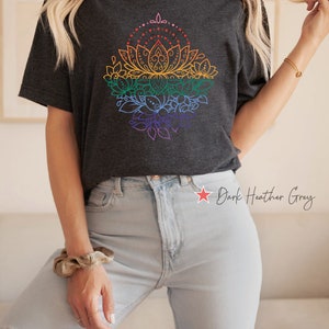 K&ouml;nnte beinhalten: Ein dunkel-melierter grauer T-Shirt mit einem Regenbogen-Mandala-Design. Das Mandala zeigt eine Lotusblume mit filigranen Details und ist von Bl&auml;ttern und Spiralen umgeben.