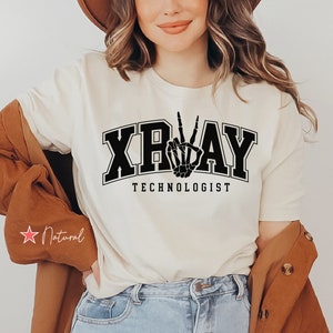 May include: A white t-shirt with a black graphic of a skeleton hand making a peace sign and the text "XRAY TECHNOLOGIST".