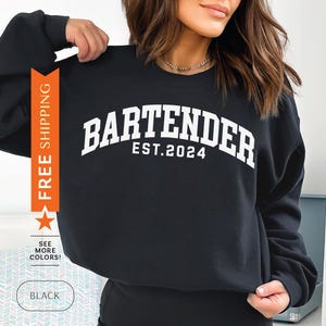 May include: Black sweatshirt with white text that reads "BARTENDER EST. 2024".