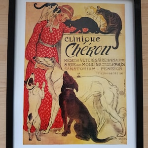 Op de afbeelding: Ingelijste vintage poster voor Clinique Cheron, een dierenkliniek in Parijs. Het kunstwerk toont een vrouw in een rode jurk met honden en katten. De poster heeft een zwarte lijst en een witte passe-partout.