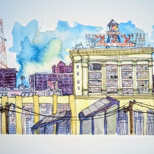 May include: Watercolor painting of an urban landscape featuring buildings, power lines, and a radio tower. The main building has a sign that reads "Cookies and Crackers". The sky is blue with watercolor clouds.