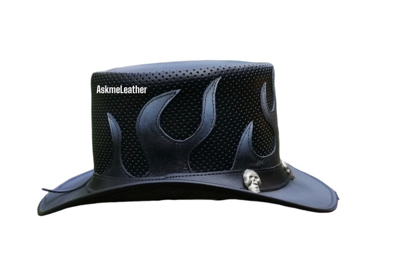 Pu&ograve; includere: Un cappello da cowboy in pelle nera con un design a fiamma e dettagli a forma di teschio. Il cappello ha una parte superiore perforata e un'ampia tesa.