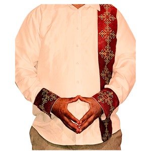 May include: A white long-sleeved shirt with red and gold trim on the cuffs and down the front. The trim features a geometric pattern.