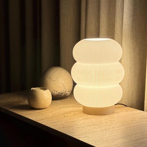 Lampe d'ambiance design allumée diffusant une lumière chaleureuse, décoration intérieure minimaliste et éco-responsable.