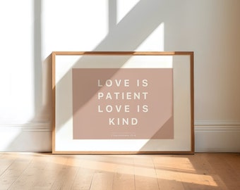 May include: A framed print with a light pink background and white text that reads "LOVE IS PATIENT LOVE IS KIND 1 Corinthians 13:4".