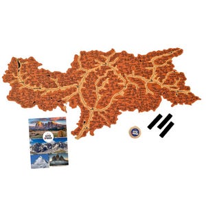 May include: A corkboard map of the Alps with the names of mountains and peaks marked. The map is brown and has a distressed look. The map is surrounded by three black strips of tape and a small round sticker with the words "Alpen Spinner" on it.