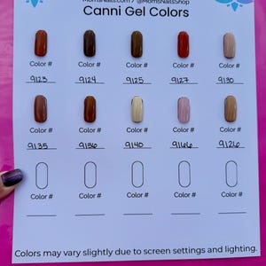 May include: A pink sheet displays a color chart of Canni Gel nail polish shades. The chart includes various colors, each labeled with a color number. The text "MomsNails" and "You Are Beautiful" are at the top, with a website address below.
