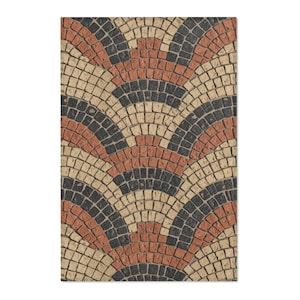 May include: A rectangular rug with a repeating fan pattern. The design features alternating bands of black, tan, and reddish-orange square tiles. The rug has a textured appearance, suggesting a durable material.