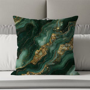 May include: A square throw pillow featuring a dark emerald green and forest green marbled pattern with flowing, organic lines. The design includes shimmering gold-colored accents and flecks that mimic the appearance of mineral veins.
