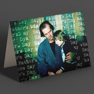 May include: A greeting card featuring a photograph of a man and a young boy. The card has a green background with the text "Happy Father's Day" repeated in a pattern.