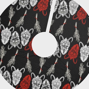 May include: Black and white tree skirt with a repeating pattern of red and white devil masks and white bundles of twigs.