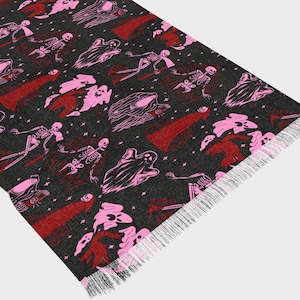May include: A black scarf with a repeating pattern of pink ghosts and skeletons. The scarf has a fringed edge.
