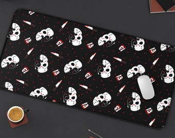Op de afbeelding: Zwart-witte muismat met een herhalend patroon van hockeymaskers en het getal 13. De maskers zijn wit met zwarte details en rode accenten. De achtergrond is zwart met rode stippen.