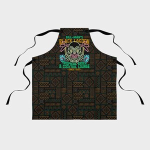 Our Gill Mans Black Lagoon Tropical Grill & Cocktail Lounge Apron is the perfect kitchen cooking accessory gift for any vintage horror movie fan that loves Creature from the Black Lagoon, Universal Monsters, and baking or cooking.