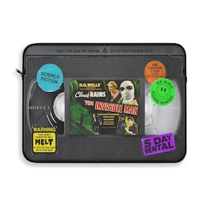 Retro Horror VHS Laptop Sleeve available in three sizes to protect your laptop. Printed on one side with a black backside, edging and zip, the perfect addition to your movie monsters, 80s, 90s, VHS tape Frankenstein, Dracula, themed desk or computer.