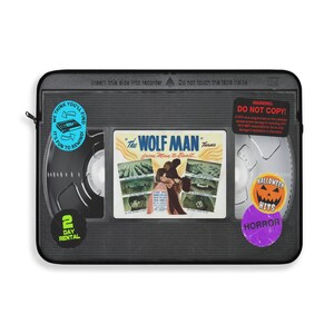 Retro Horror VHS Laptop Sleeve available in three sizes to protect your laptop. Printed on one side with a black backside, edging and zip, the perfect addition to your movie monsters, 80s, 90s, VHS tape Frankenstein, Dracula, themed desk or computer.