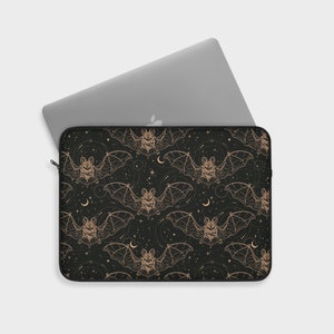May include: A black laptop sleeve with a repeating pattern of gold bats and stars on a black background.