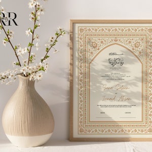 May include: A framed Islamic wedding certificate with intricate gold and peach floral designs. The certificate features Arabic calligraphy and the names Sana Saleem and Junaid Ahsan.