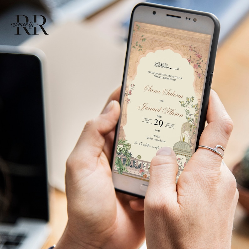 Puede incluir: Una invitaci&oacute;n digital en la pantalla de un tel&eacute;fono inteligente para una ceremonia de boda. La invitaci&oacute;n presenta un dise&ntilde;o floral con una mezquita en el fondo. El texto dice "Por favor, &uacute;nase a nosotros para celebrar la ceremonia Nikah de Sana Saleem con Junaid Ahsan el 29 de diciembre de 2021."