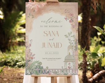 May include: A wedding welcome sign with a floral design and the text "welcome to the wedding of Sana and Junaid 10.12.2021 "And We created you in pairs"  Surah Ar-Rum - Verse 21"