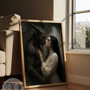 May include: A framed rectangular wall art print featuring a dark-skinned horned creature with glowing eyes standing close to a person with long black hair wearing a cream-colored long-sleeved dress. The print includes the text Dream Digital by Lisa.