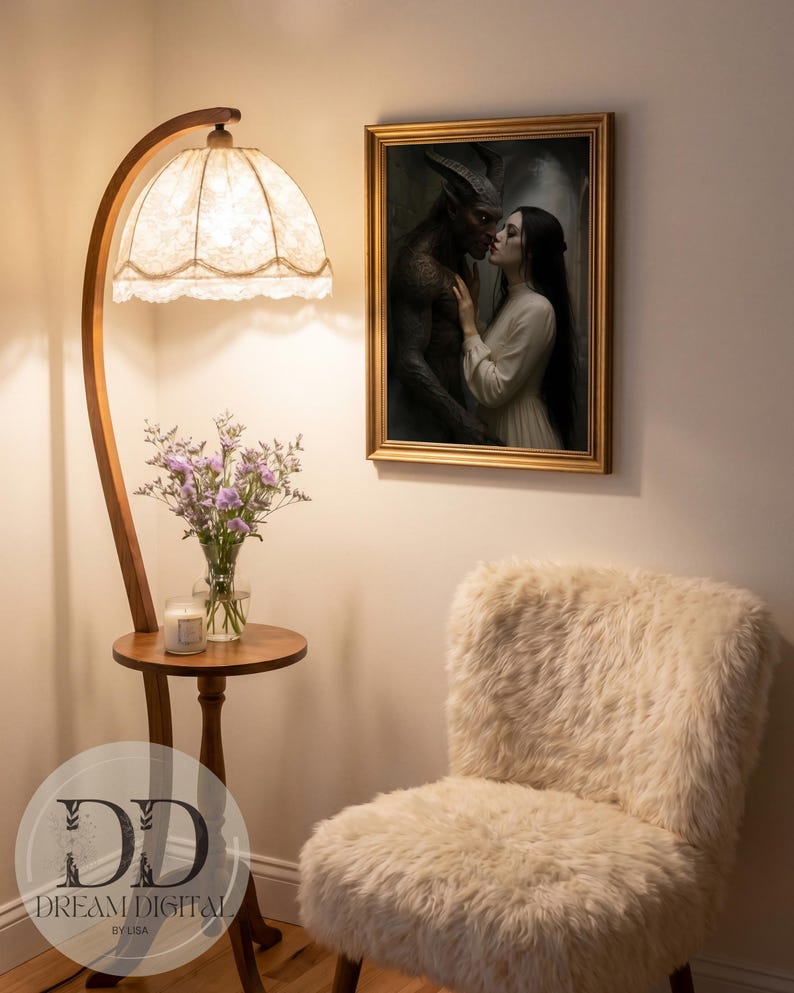 May include: A framed wall art print depicting a dark horned figure and a person in a cream dress, positioned near a wooden floor lamp with a lace shade, a small round table holding a glass vase of purple flowers, and a cream-colored faux fur chair.