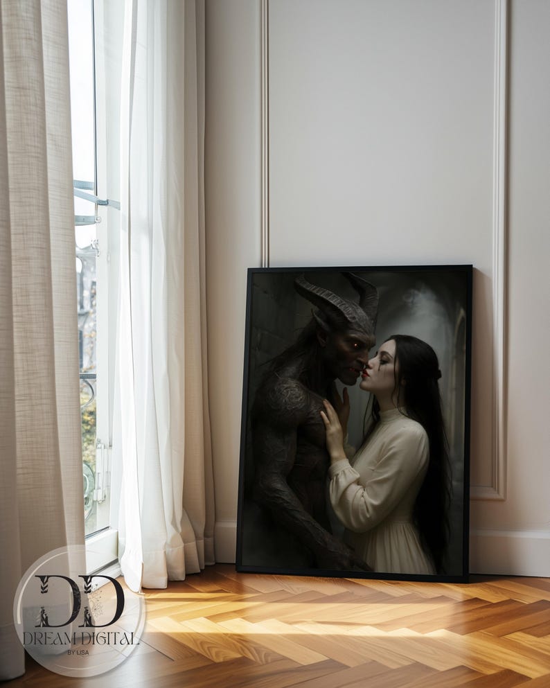 May include: A rectangular framed wall art print featuring a dark-skinned horned creature with glowing red eyes and a person with long dark hair wearing a cream-colored long-sleeved dress. The two figures are positioned face-to-face in a close embrace.