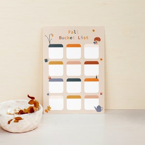 May include: A printable fall bucket list with a colorful illustration of a mushroom and a teapot. The list has 16 blank squares to fill in with fall activities.