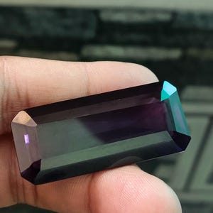 以下が含まれることがあります： 長方形でファセットカットされた、濃い紫と緑の宝石