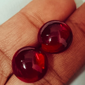 Könnte beinhalten: Zwei runde, rote Edelsteine mit hochglänzender Oberfläche.