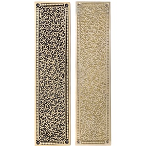 May include: Two rectangular brass door finger plates with intricate floral patterns. One plate has a dark finish, the other a lighter, aged brass tone. Each plate has rounded corners and small screw holes.