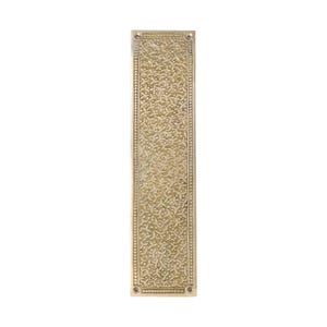 May include: A rectangular, brass-colored door finger plate with an intricate, repeating floral pattern. The plate has a detailed border and four screw holes, suggesting a vintage or antique style.