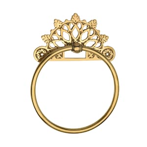 May include: A gold-colored towel ring with an ornate, decorative design. The ring is circular and attached to a rectangular backplate with a detailed, floral-inspired pattern. The top of the backplate features a semi-circular, openwork design.