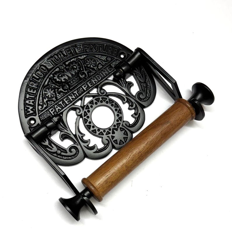 May include: Black cast iron toilet paper holder with a wooden roller and the text "Waterloo Toilet Fixture Patent Pending" on the front.