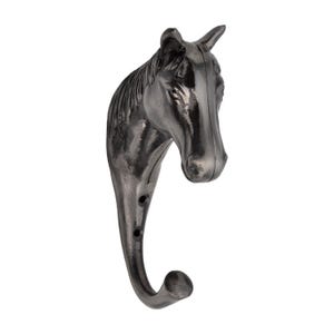 May include: A dark gray metal wall hook shaped like a horse head. The hook has a curved design with three small holes and a rounded end. The horse head is detailed with a mane and facial features.