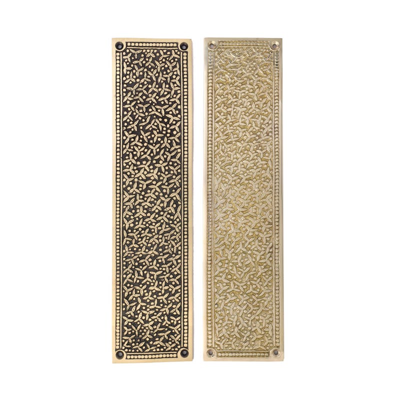 May include: Two rectangular brass door finger plates with intricate floral patterns. One plate has a dark finish, the other a lighter, aged brass tone. Each plate has rounded corners and small screw holes.