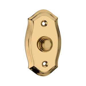 Può includere: Un pulsante per campanello in ottone lucido con una forma curva decorativa. Il pulsante è centrato sulla placca, con due fori per viti sopra e sotto. La finitura è lucida e riflettente.