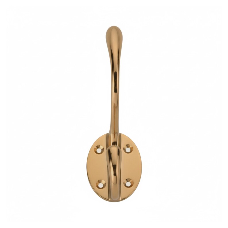 May include: A gold-colored wall hook with an oval base and a curved hook. The hook is made of metal and has a polished finish. The oval base has four screw holes for mounting. This decorative hook is suitable for coats, hats, or other items.