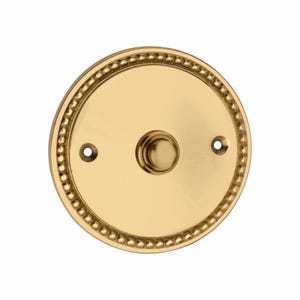Può includere: Un pulsante per campanello circolare in ottone con finitura dorata lucida. La piastra presenta un bordo decorativo a perline lungo il perimetro esterno e due piccoli fori per le viti sui lati sinistro e destro per il montaggio. Include un pulsante centrale.